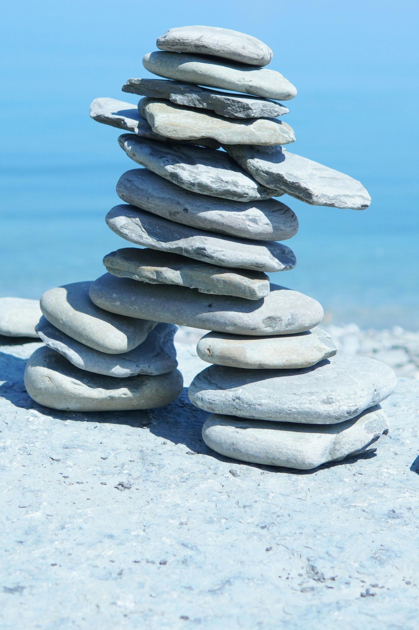 rocks pile ontop of each other balancing on a beach shore